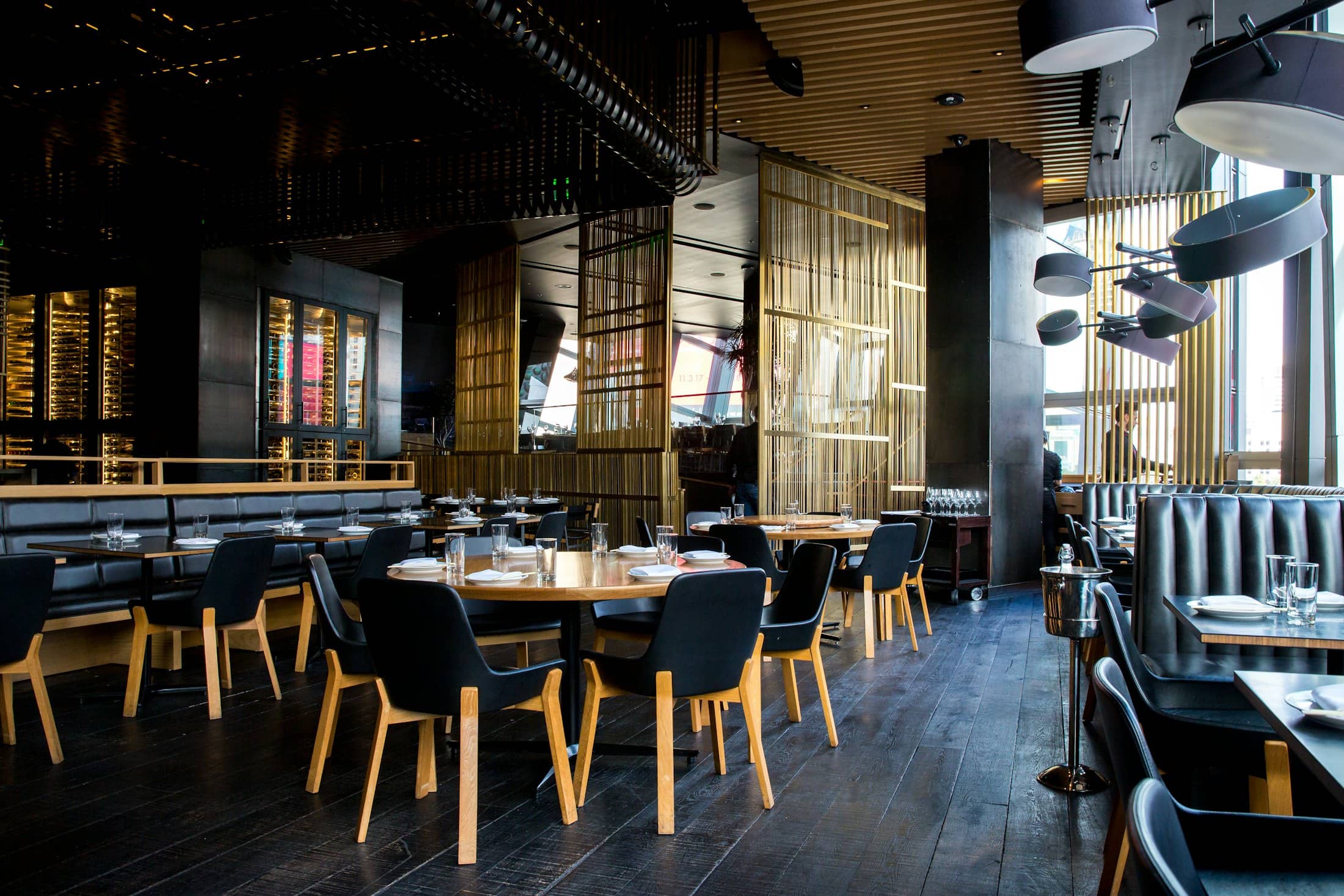 An empty restaurant dining room with dark wood tables before service