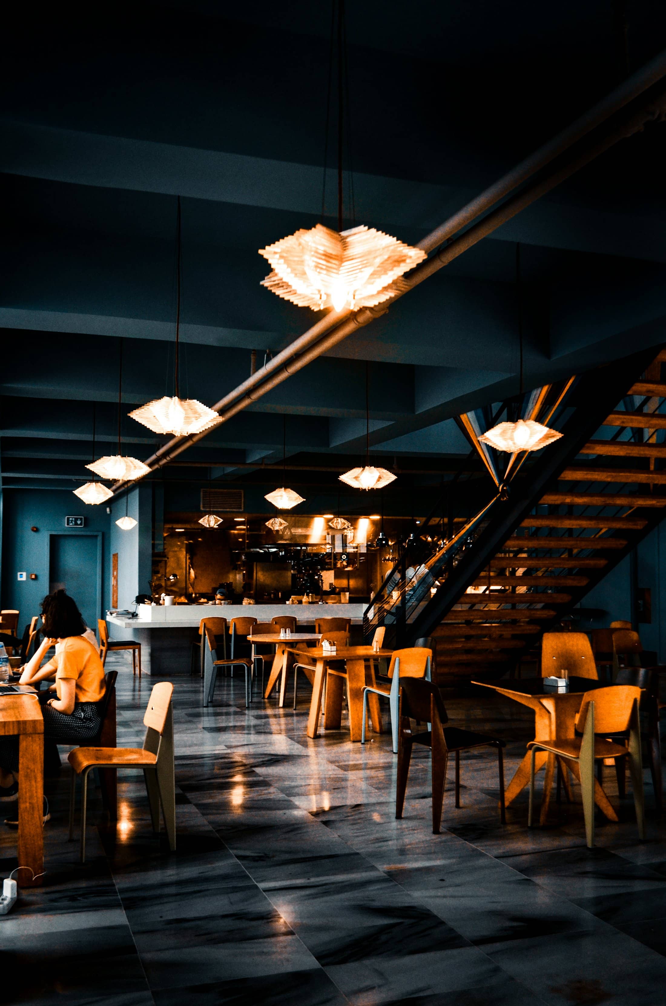 A restaurant dining room at night with low warm lighting
