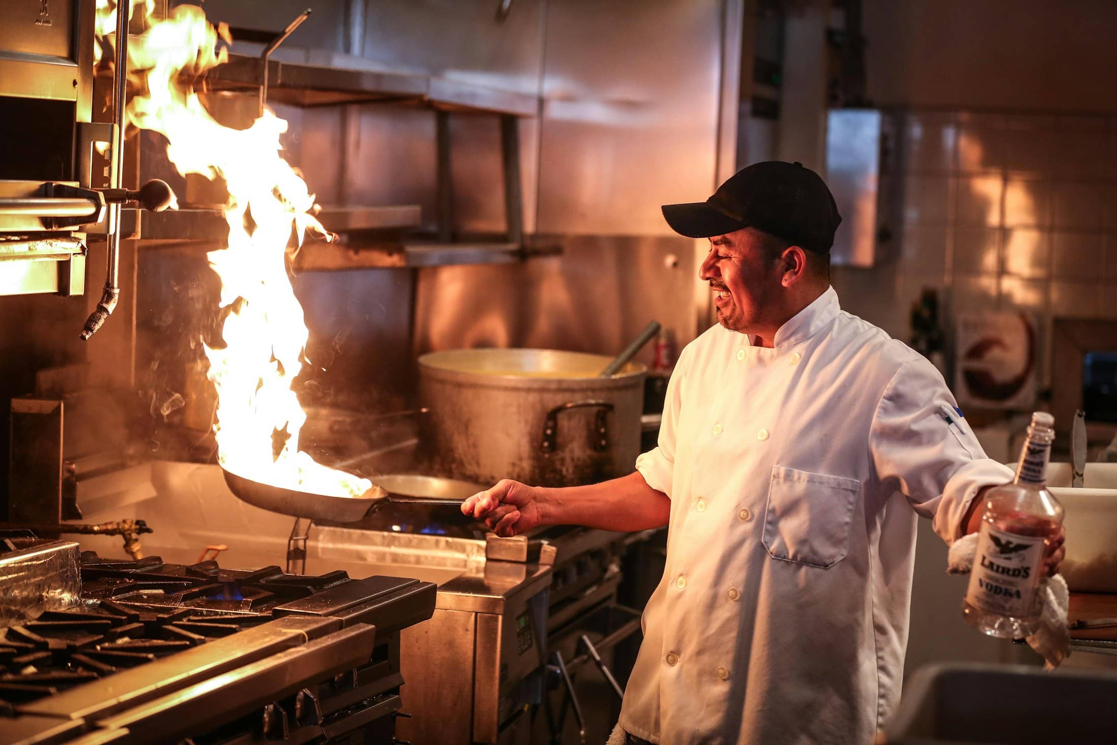 A chef tossing a flaming wok in a restaurant kitchen